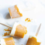 overhead shot of orange and white popsicles on wooden popsicle sticks