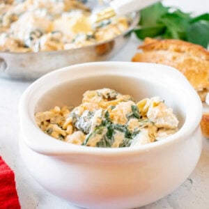 crockpot spinach artichoke dip served in a small white bowl