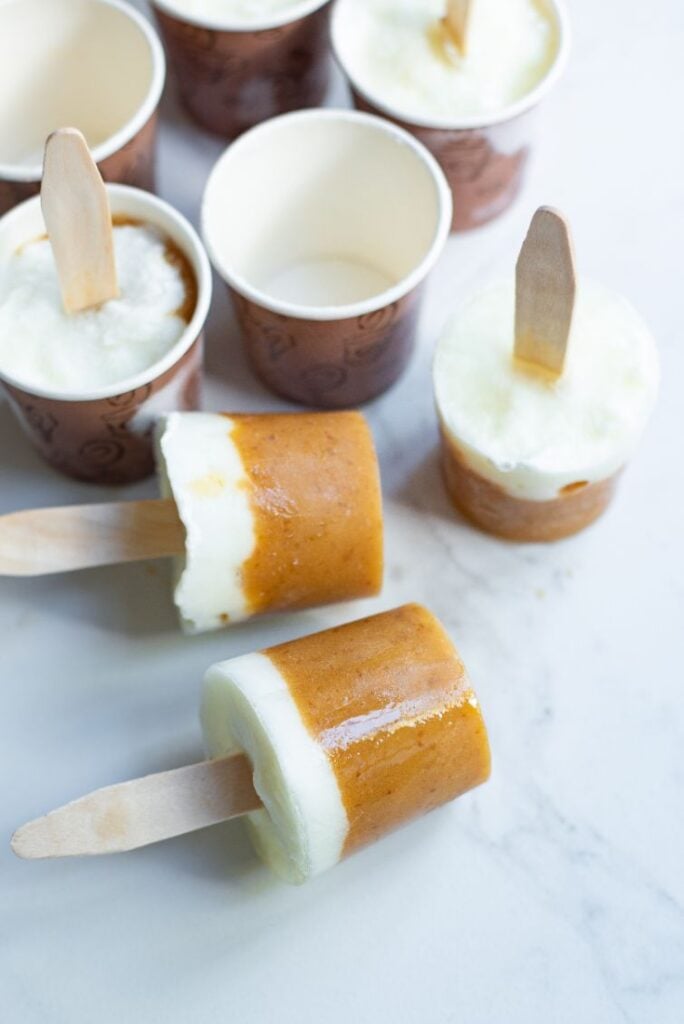 Mango popsicles removed from small espresso cup popsicle molds