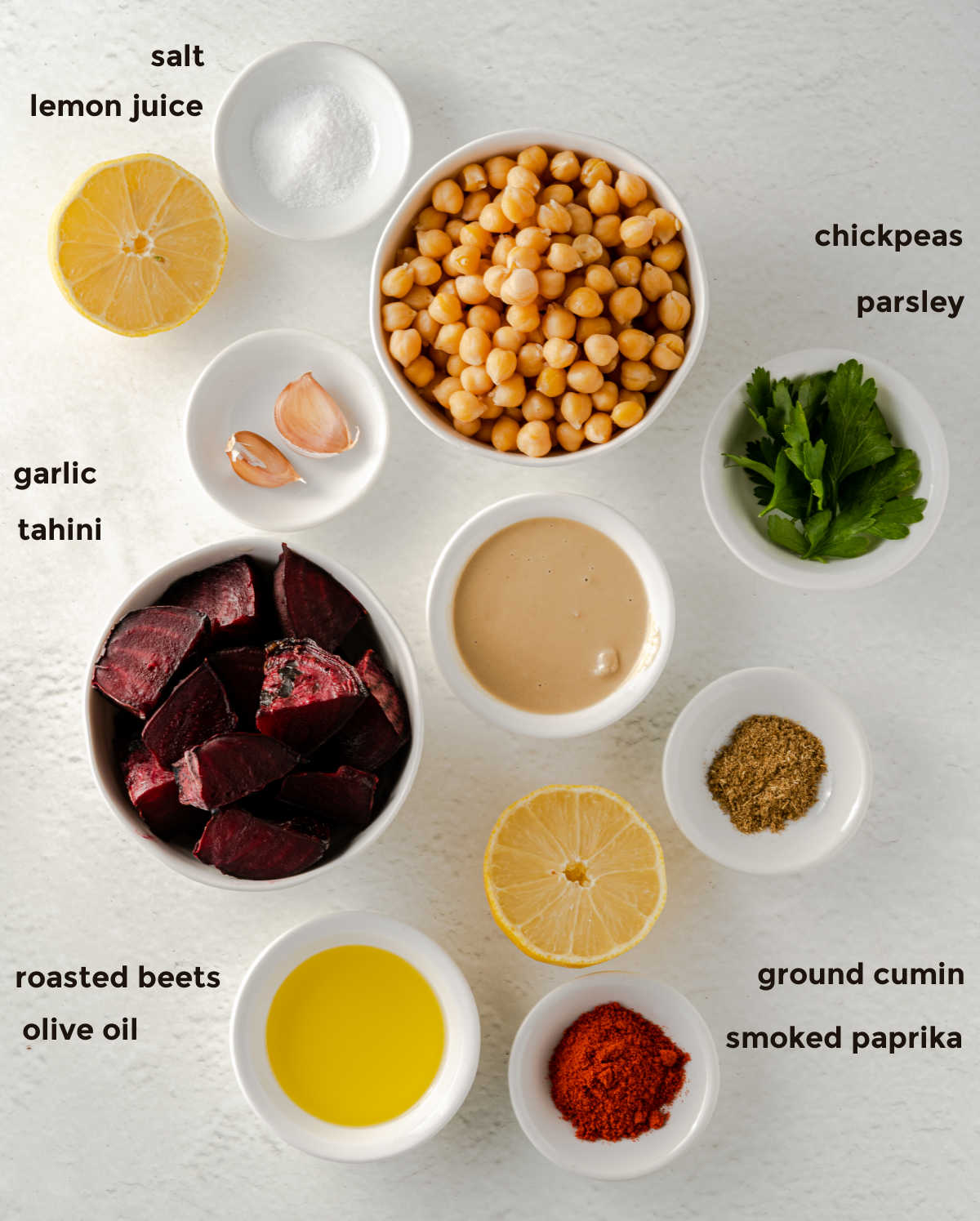 Overhead ingredient shot of all of the ingredients required for a traditional hummus but also some roasted beets