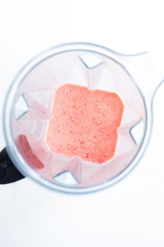 overhead shot of blended strawberries in a blender jug