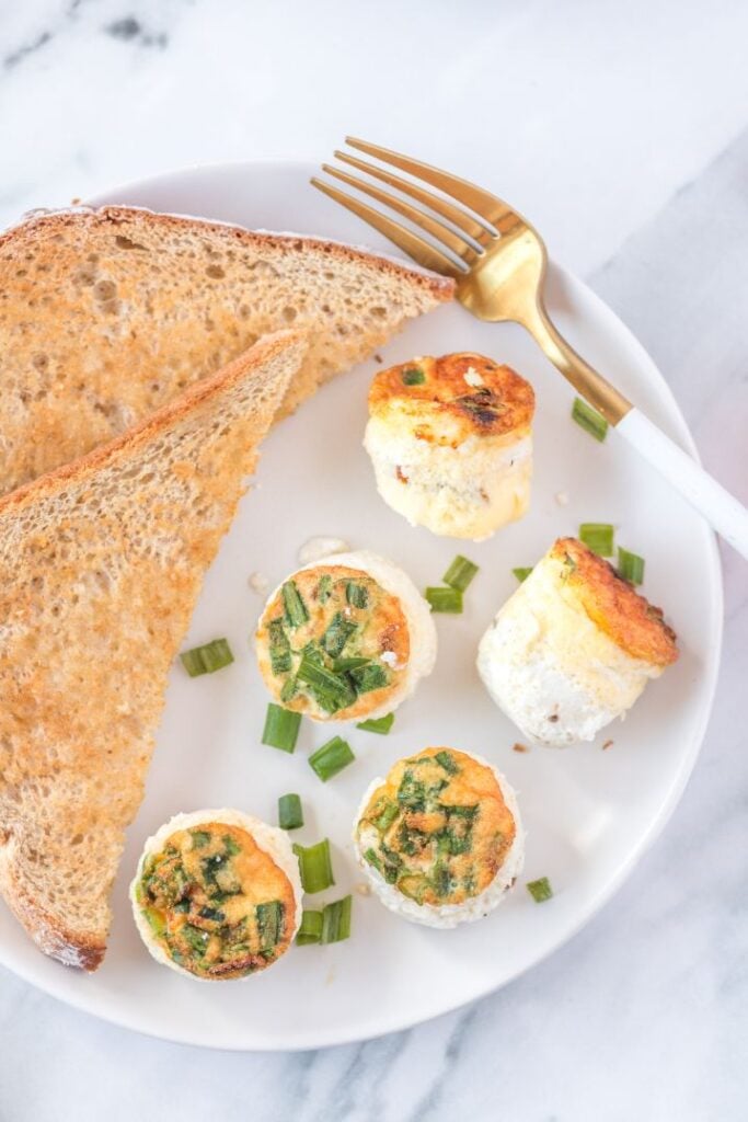 Overhead shot of starbucks egg bites served on a white plate with a side of toast