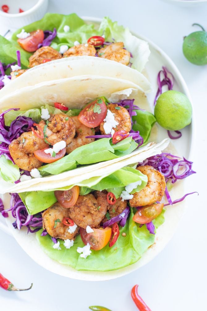 Overhead shot pf prawn tacos loaded with lettuce and purple cabbage