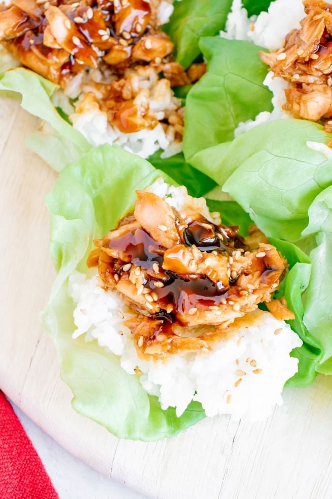 Up close shot of teriyaki salmon served in a lettuce leaf with some rice