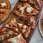 individual slices of low carb pizza served on a long wooden board