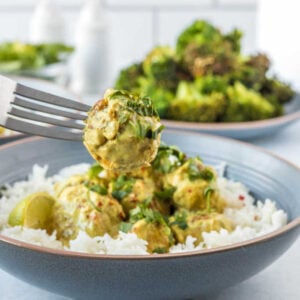 Curry meatballs being picked up from a bowl with a fork