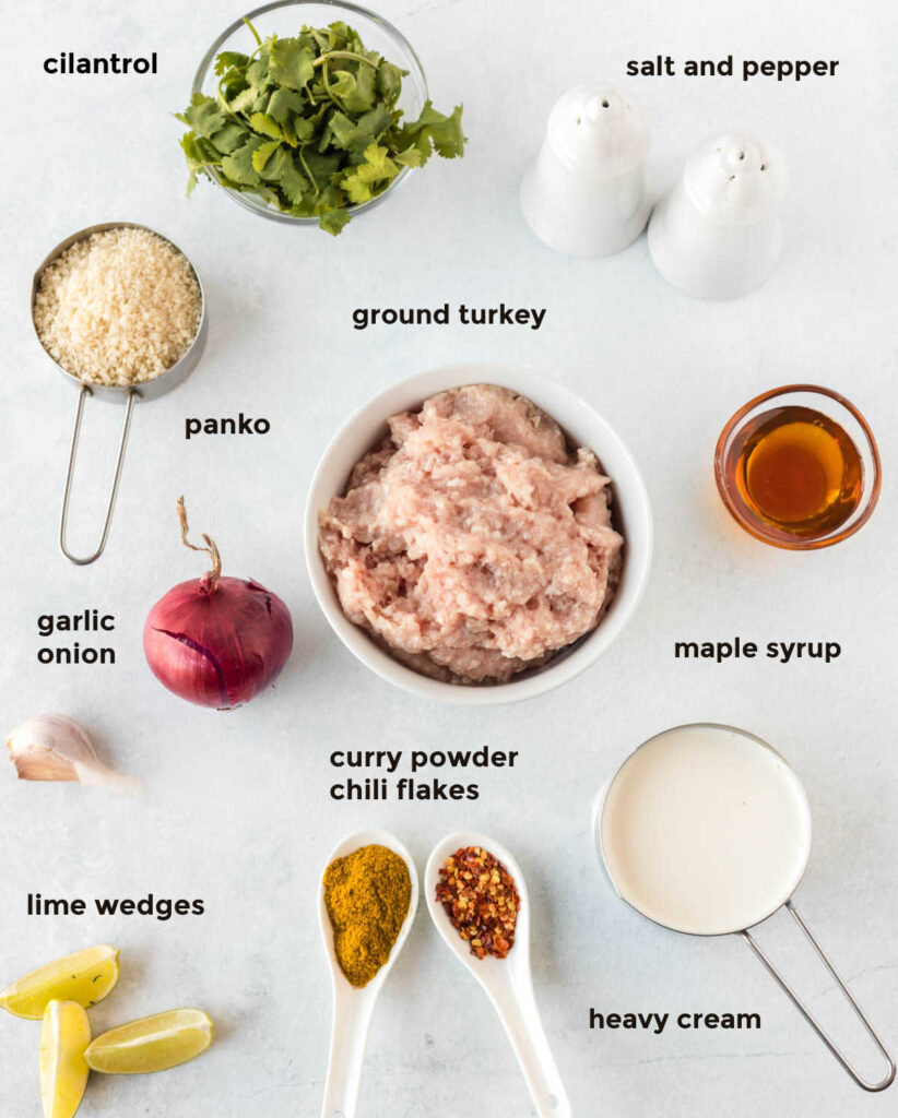 Overhead ingredient shot for turkey meatballs. All of the ingredients are spread out against a white background and in their own containers.