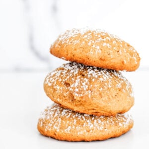 A stack of 3 pumpkin cookies against a white background