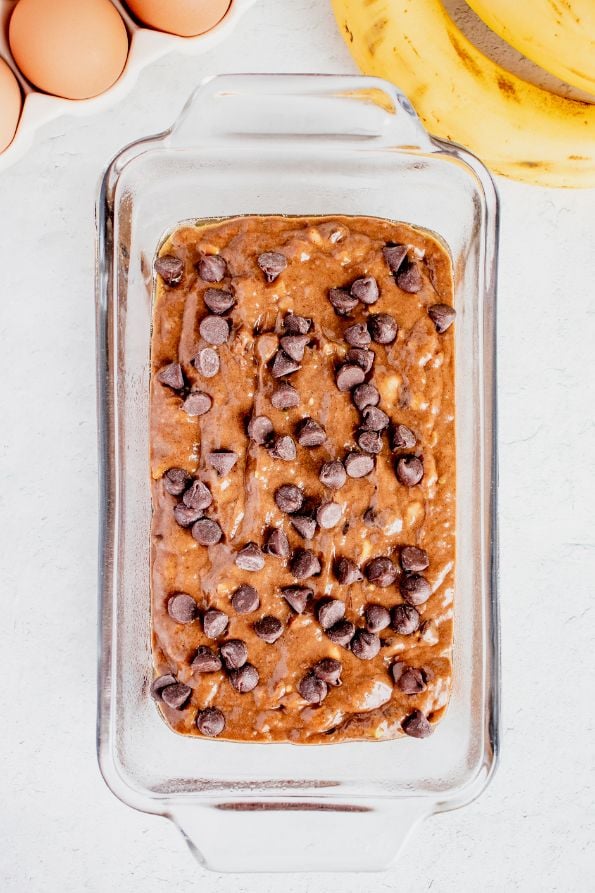 Overhead shot of banana bread batter in a glass loaf pan