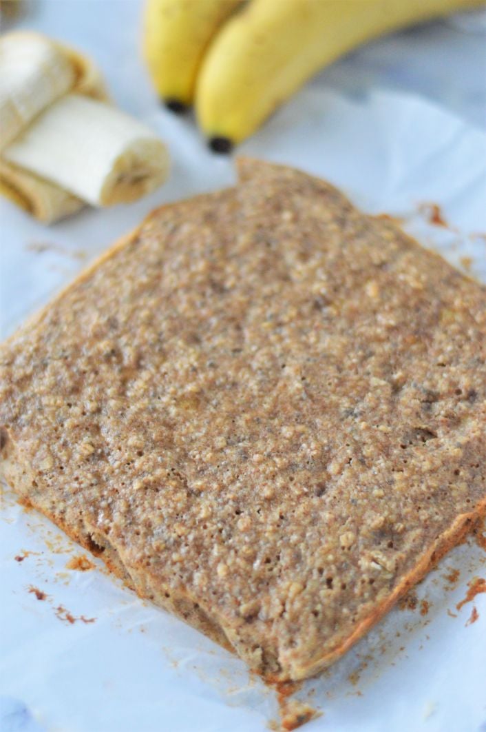 Almond butter banana bread bar cooling on some parchment paper