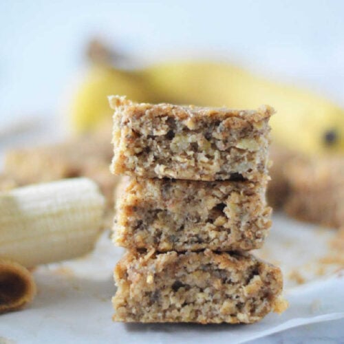 Banana bars cut into evenly cut squares and stacked one on top of the other