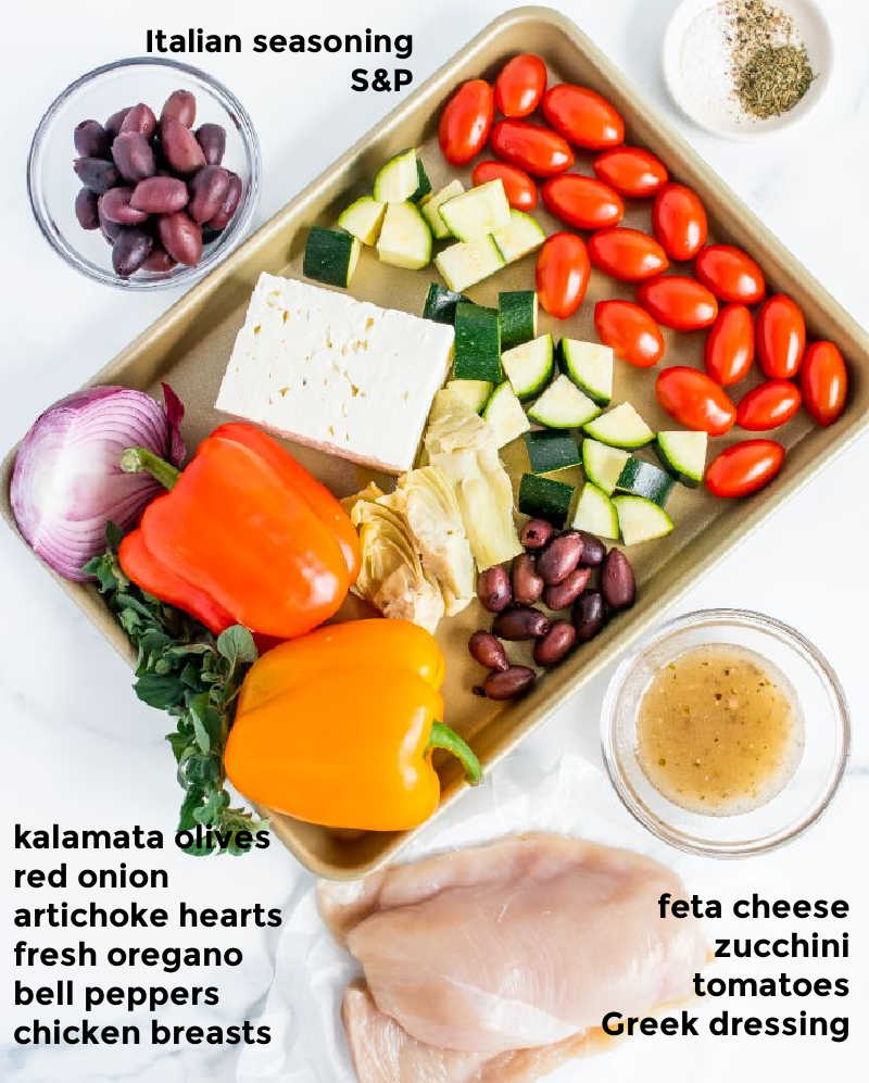 Overhead ingredient shot of all ingredients needed for making Greek chicken and veggies laid out on a sheet pan