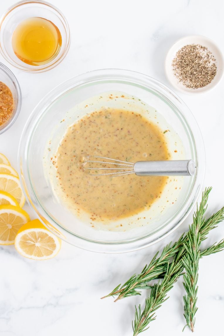 Honey mustard marinade ingredients whisked together in a glass bowl