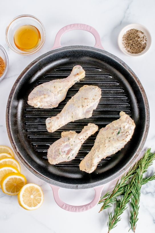 4 chicken drumsticks added to a hot cast iron grill pan