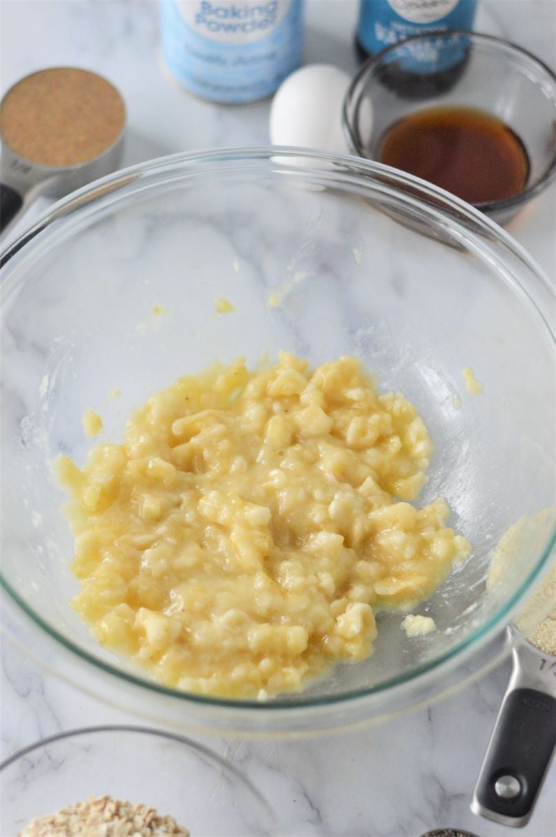 A glass bowl containing mashed banana