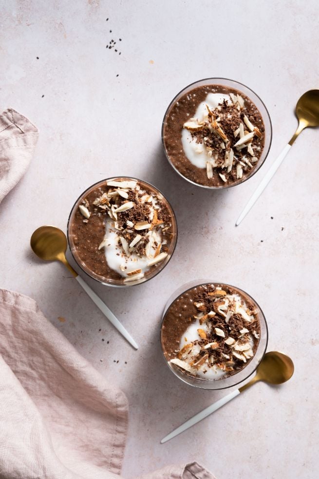 Chocolate, yogurt and chopped nuts added to a chia pudding served in 3 small mason jars 