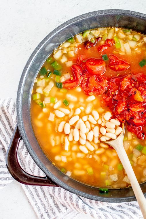 Stock, beans, diced tomato and chicken added to a large soup pot