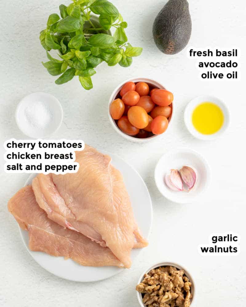 Overhead ingredient shot of grilled pesto chicken breast ingredients with all ingredients served in small white bowls