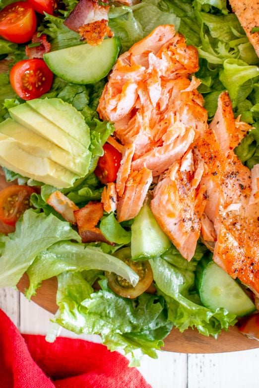 Flaked salmon fillets on top of a salad