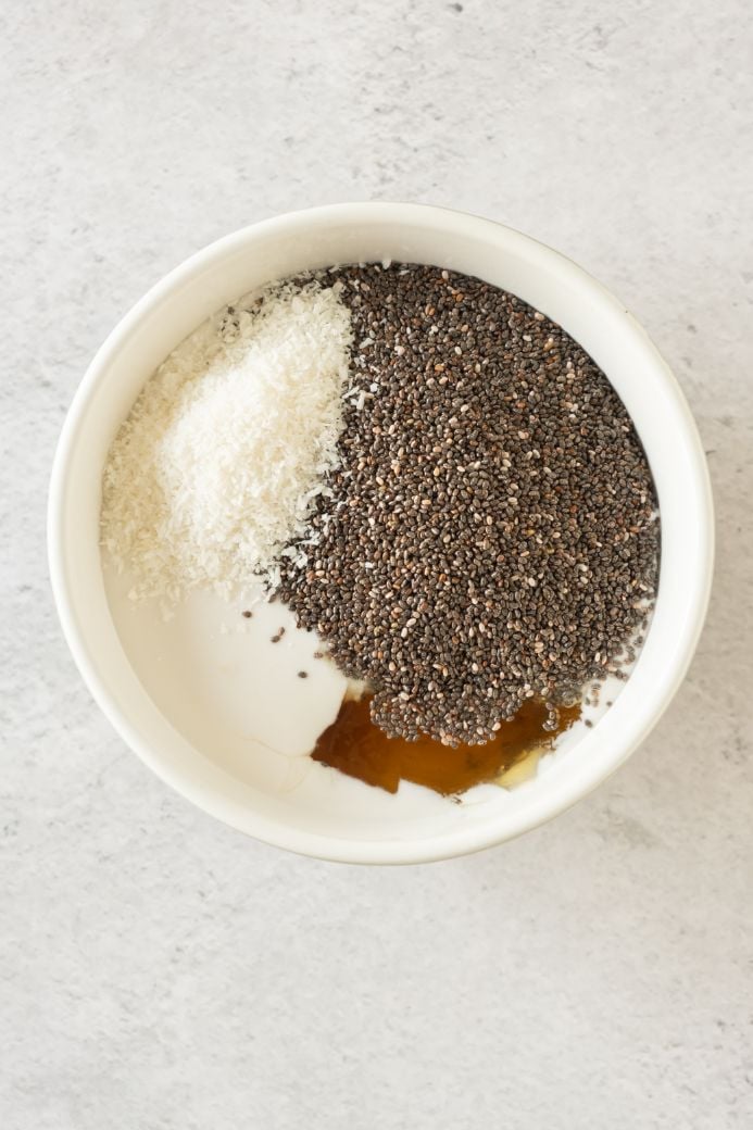 Ingredients for a creamy chia pudding added to a white bowl