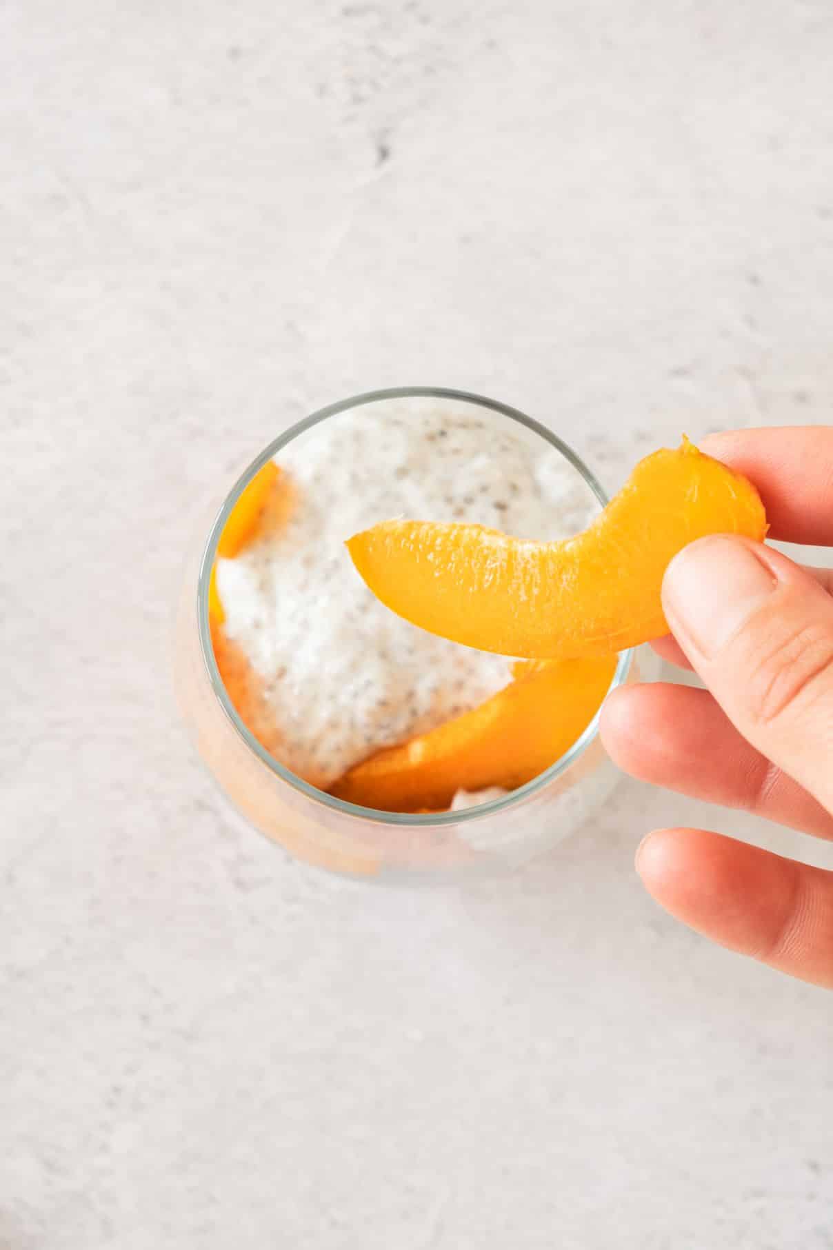 Layering slices of ripe apricot on top of a creamy chia pudding