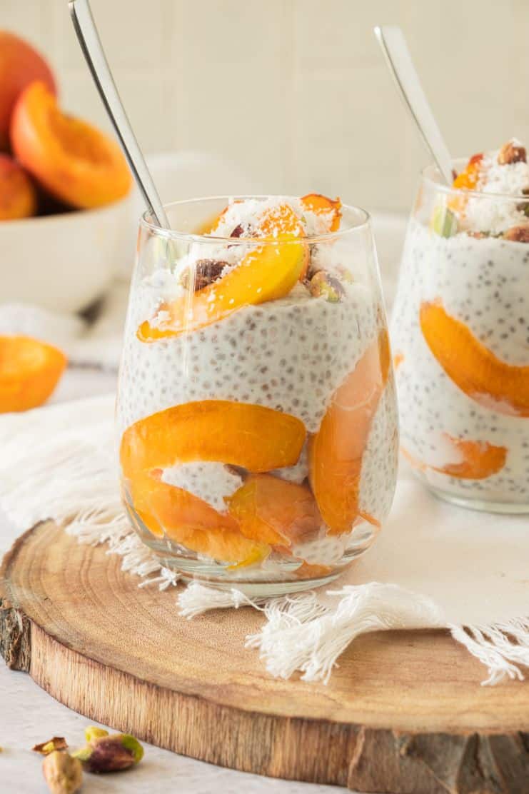 chia pudding with fresh apricot slices served in a tall glass