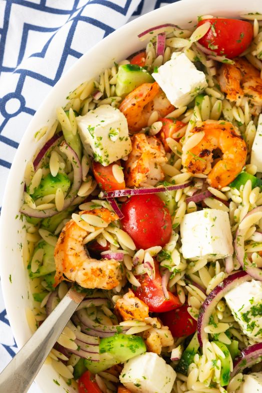 overhead shot of a pesto orzo and shrimp pasta served in a large white bowl