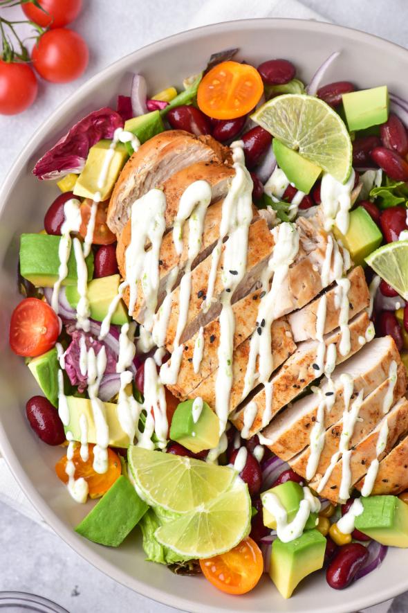 Salad with chicken breast and a yogurt dressing drizzle