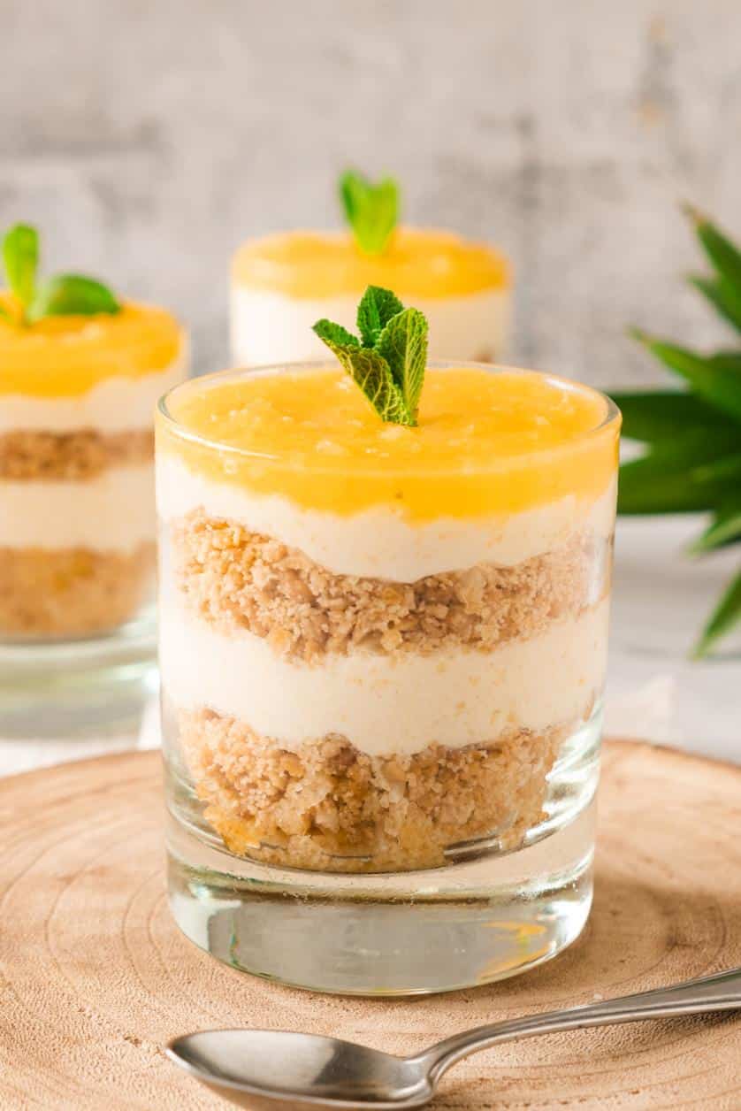 A no bake cheesecake layered in a glass and topped with fresh mint