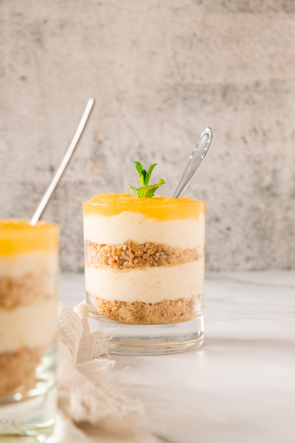 Layers of biscuit crumble, cheese cream and pineapple puree in glasses