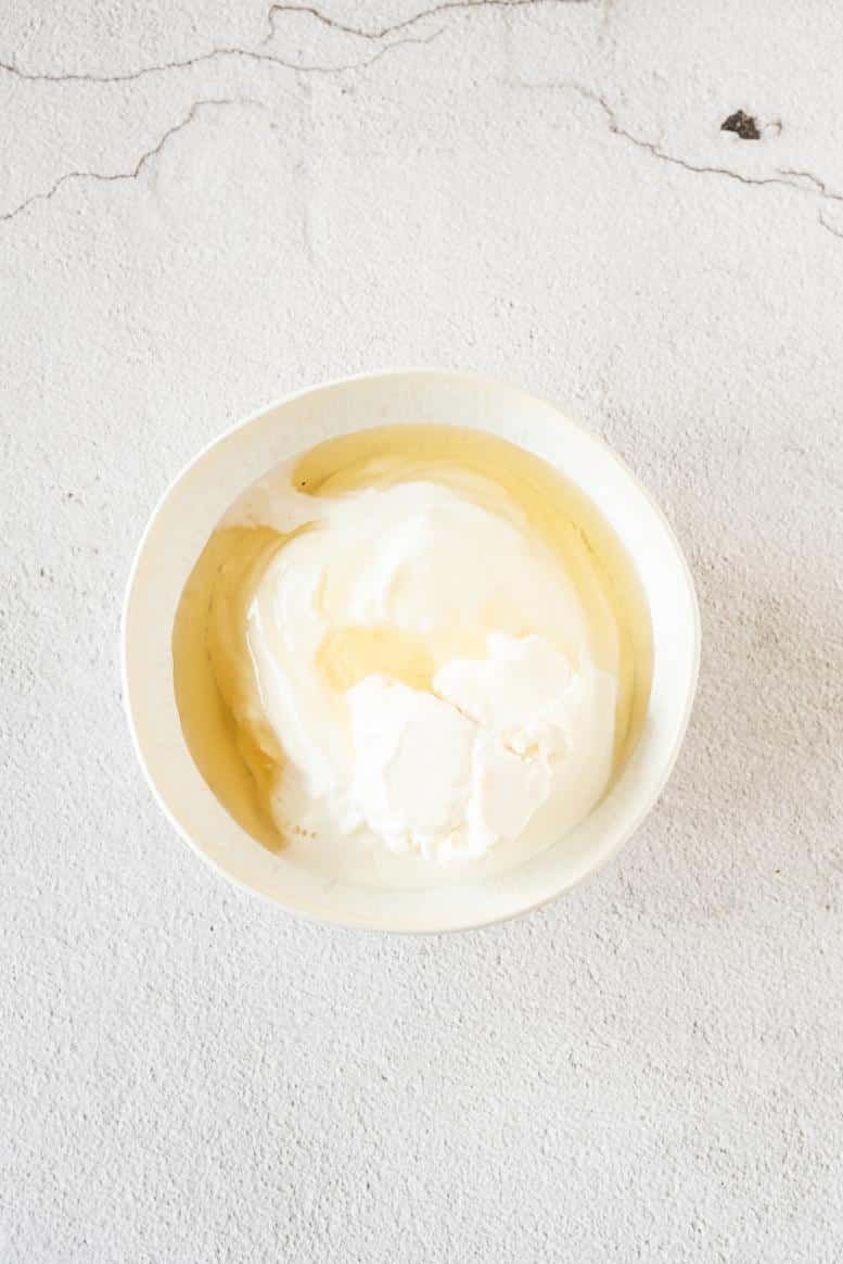 A small white bowl containing mascarpone, yogurt and agave syrup