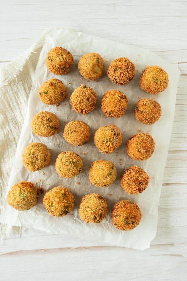 Panko coated broccoli cheese balls arranged on parchment paper