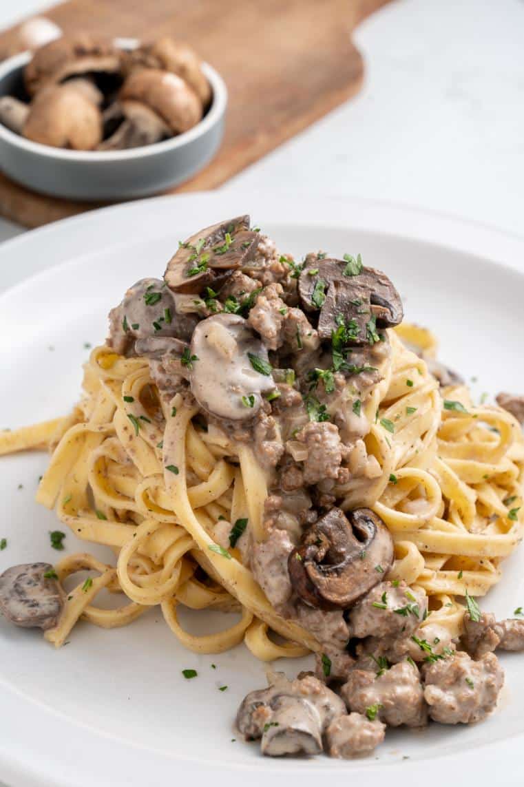 Mushroom and ground beef sauce on top of hot buttered noodles