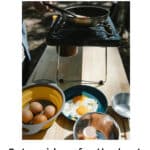 a table with some eggs and a small outdoor grill cooking some eggs
