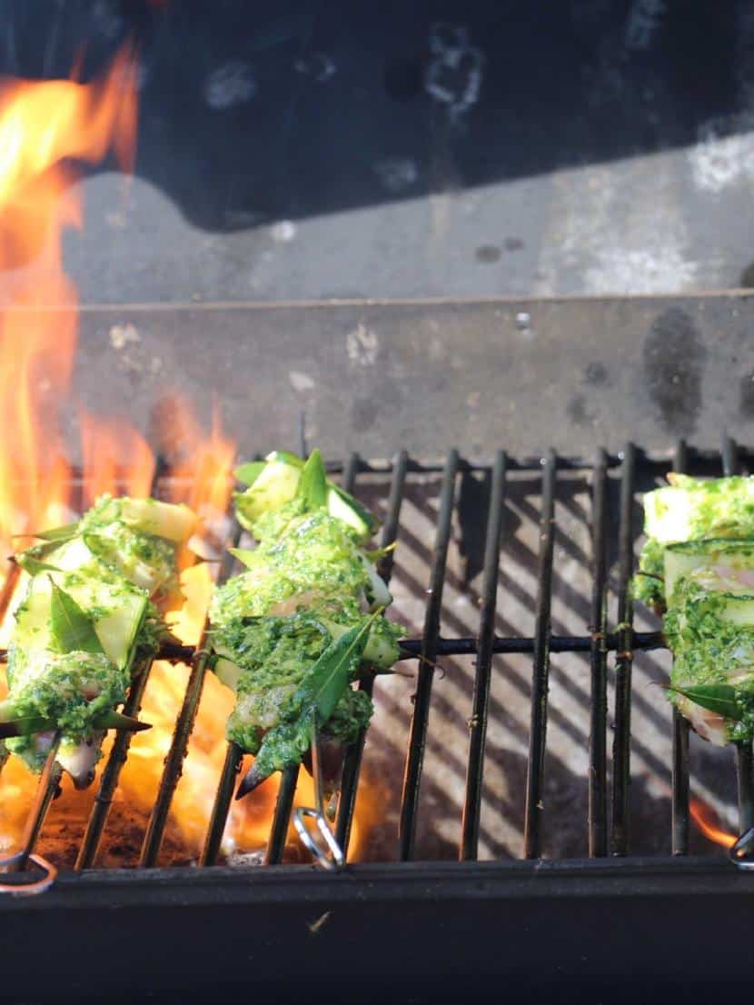 Small grill cooking some chicken and zucchini skewers