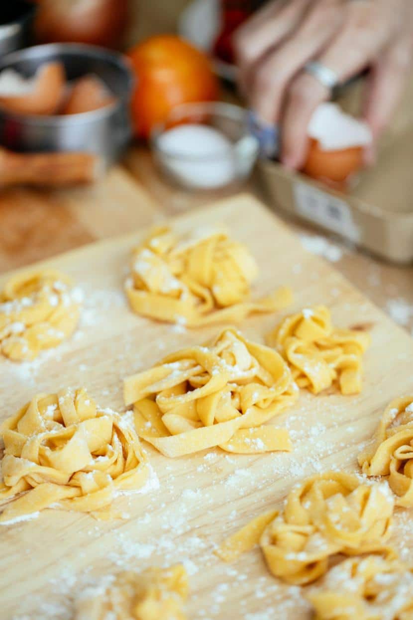 Parcels of homemade pasta on a chopping board dusted with flour