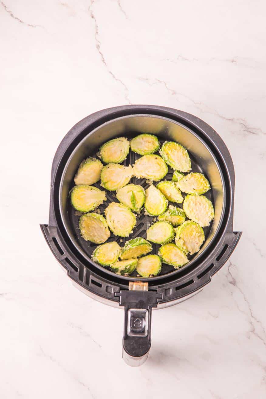 Prepared Brussels sprouts added to the basket of an air fryer