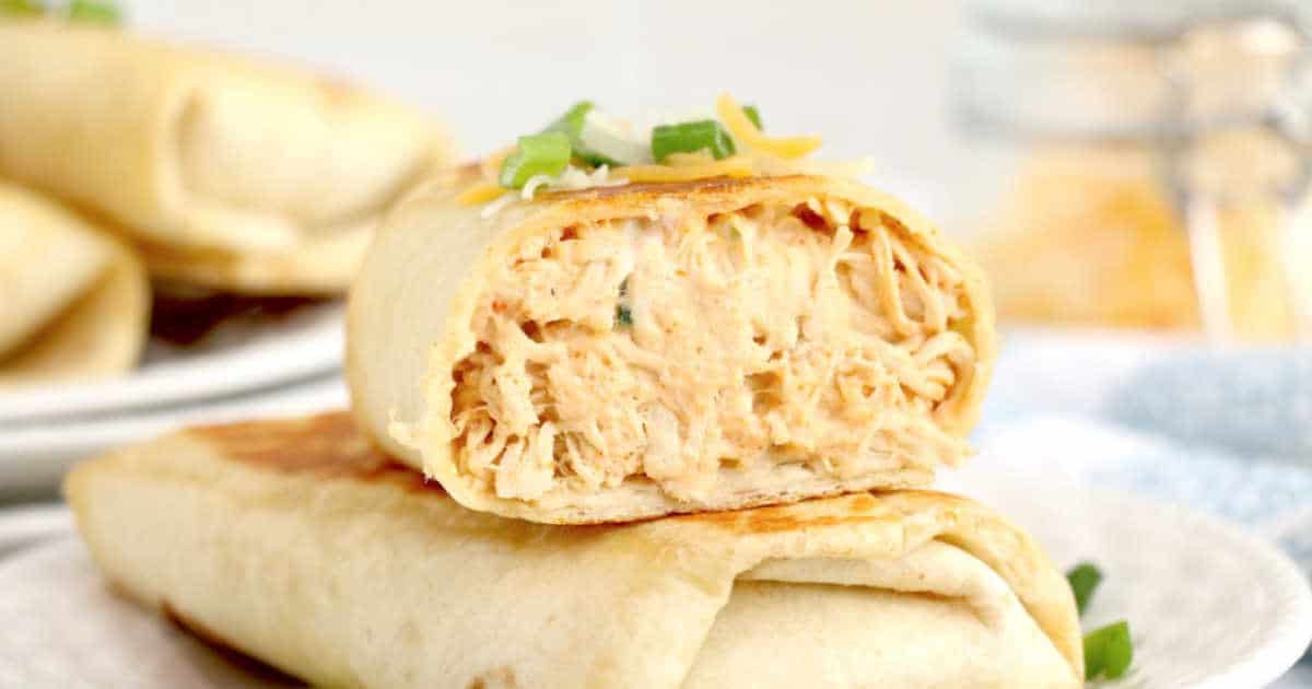 Two halves of a chicken wrap stacked on top of each other and garnished with some fresh parsley