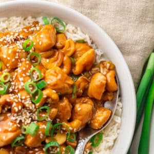 Quick and easy chicken cashew stir fry served in a white bowl with steamed rice